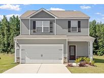 Charming two-story home with a two-car garage, gray siding, and a well-manicured lawn at 154 Taverners Ln, Angier, NC 27501