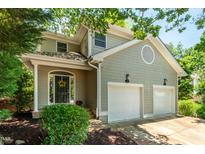 Charming two-story home featuring a two-car garage, arched front door and mature landscaping at 219 W Columbia Pl, Chapel Hill, NC 27516