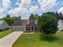 Charming two-story home with a well-manicured lawn, solar panels, and a spacious two-car garage at 236 Emma Ct, Linden, NC 28356