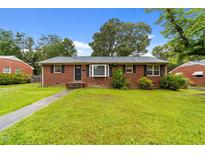 Charming red brick home with a well-maintained lawn and mature trees, offering a welcoming curb appeal at 2512 Mckinney St, Burlington, NC 27217