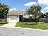 Charming single-story home featuring a well-manicured lawn, mature trees, and an attached garage at 305 Wallington Ct, Mebane, NC 27302