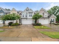Charming townhome exteriors with manicured lawns, gardens and attached garages offer curb appeal at 3215 Retama, New Hill, NC 27562