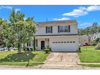 Charming two-story home featuring a two-car garage and landscaped front yard on a sunny day at 3604 Rivermist Dr, Raleigh, NC 27610