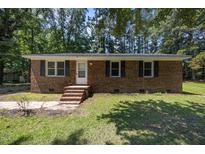 Charming one-story brick home with a well-maintained lawn and classic black shutters at 37 Weeping Willow Ln, Lillington, NC 27546