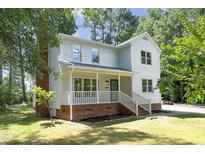 Charming two-story home with a welcoming front porch and beautifully landscaped yard at 409 Glaive Dr, Durham, NC 27703