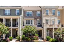 Charming townhome featuring a brick facade, front porch, and well-maintained landscaping at 417 Austin View Blvd, Wake Forest, NC 27587