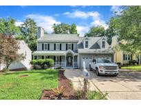 Charming two-story home featuring a welcoming front porch, well-manicured lawn, and an attached two-car garage at 4309 Birmingham Way, Raleigh, NC 27604