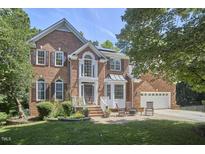 Charming brick home featuring a well-manicured lawn, brick stairs, and a two-car garage at 5328 Willow Cry Ln, Raleigh, NC 27613
