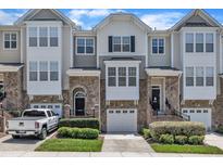 Charming townhome with stone accents, attached garages, and well-manicured landscaping, offering a desirable curb appeal at 5824 Cameo Glass Way, Raleigh, NC 27612
