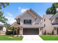 Charming two-story home featuring a gray roof, a two-car garage, and a well-manicured lawn at 703 E Markham Ave, Durham, NC 27701
