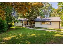 Charming one-story home with white brick exterior and landscaped front yard at 944 Athens Dr, Raleigh, NC 27606