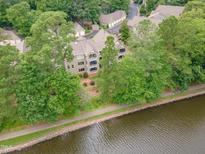 Scenic aerial view of the condo building along the water with mature trees and green foliage at 0317 Glen Echo Ln # C, Cary, NC 27518