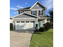 Charming two-story home featuring a two-car garage, manicured lawn, and inviting turquoise front door at 109 E Webber Lane Ln, Clayton, NC 27527