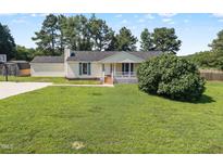 Charming single-story home with a well-maintained lawn, covered porch, and basketball court at 111 Marshay Meadow Rd, Youngsville, NC 27596