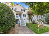 Inviting two-story condo with a light yellow exterior, black shutters, and landscaped front yard at 117 Scott Ln, Chapel Hill, NC 27514