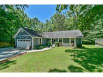 Charming single-story home with a well-manicured lawn, attached garage and flowering window boxes at 1205 Hillsborough Rd, Chapel Hill, NC 27516