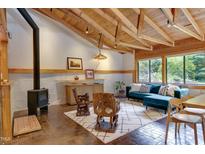 Inviting living room featuring a beamed ceiling, wood burning fireplace, and large picture windows at 1320 Shepherd St, Durham, NC 27707