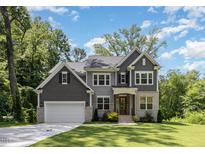 Beautiful two-story home featuring a lush green lawn and mature trees providing ample shade at 1417 Westmoreland Dr, Raleigh, NC 27612