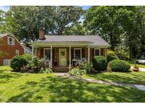 Charming single-story home with a brick facade, covered front porch and mature landscaping at 1542 W Davis St, Burlington, NC 27215