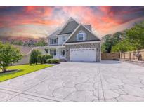 Charming two-story home with stone accents, spacious driveway and a manicured lawn under a vibrant sunset at 168 Melody Ln, Cameron, NC 28326