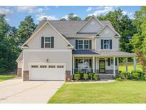 Charming two-story home with a well-maintained lawn, attached garage and inviting front porch at 1726 Rapids Ct, Franklinton, NC 27525