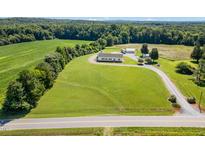 Expansive aerial view of a country home with sprawling lawn, mature trees and outbuildings at 190 Mitchells Chapel Road, Pittsboro, NC 27312