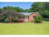 Charming brick home featuring a lush lawn and mature trees in a desirable neighborhood at 1975 Oakridge Duncan Rd, Fuquay Varina, NC 27526