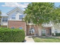 Charming two-story townhouse with brick accents, a landscaped yard and a sidewalk leading to the front door at 2101 Piney Brook Rd # 102, Raleigh, NC 27614