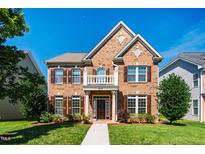 Charming brick two-story home with manicured lawn, decorative columns, and inviting front porch at 2129 Glade Valley Ln, Morrisville, NC 27560