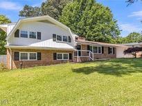 Charming brick home featuring a gambrel roof design and a lush green front lawn at 2300 Radius Cir, Sanford, NC 27330