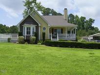 Inviting two-story home featuring a charming front porch, well-manicured lawn, and mature trees at 2817 Buckboard Ln, Raleigh, NC 27603