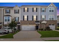 Charming townhome with brick facade, attached garage, and well-maintained landscaping at 333 Amber Acorn Ave, Raleigh, NC 27603