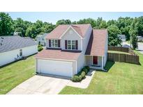 Charming two-story home featuring neutral siding, a well-manicured lawn, and an attached two car garage at 4125 Scofield Dr, Raleigh, NC 27610