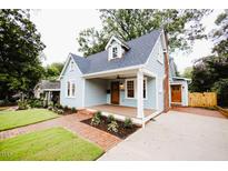 Charming home featuring a covered front porch, brick walkway, and a manicured lawn at 415 E Lavender Ave, Durham, NC 27704