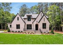 Charming two-story home featuring a brick facade, gabled roof, and lush landscaping at 503 Damascus Church Rd, Chapel Hill, NC 27516