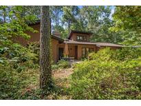 Charming home featuring a wood exterior surrounded by lush greenery and mature trees at 6700 Falconbridge Rd, Chapel Hill, NC 27517