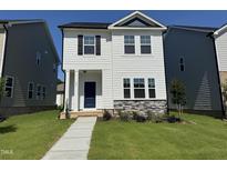 Charming two-story home with a well-maintained lawn and stone accents at 801 Portland Rose Dr, Knightdale, NC 27545