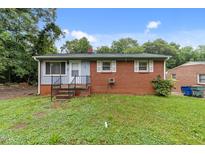 Cozy, brick home featuring a tidy front yard and welcoming entrance steps at 807 New St, Graham, NC 27253
