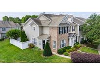 Charming townhome featuring brick accents, manicured lawn, and lush landscaping for a welcoming curb appeal at 818 Bryant St, Raleigh, NC 27603