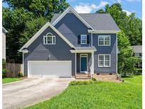 Charming two-story home with blue siding, white trim, two car garage, and well-manicured lawn at 9508 Waterwood Ct, Raleigh, NC 27614