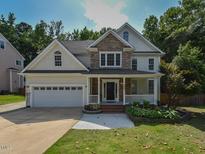 Charming two-story home featuring a stone facade, attached garage and manicured front lawn at 1005 Fairfax Woods Dr, Apex, NC 27502