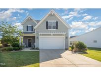 Charming home with light gray siding, black shutters, and a two-car garage with a concrete driveway at 123 Teaser Dr, Fuquay Varina, NC 27526