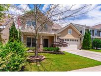Charming two-story home featuring a manicured lawn and a two-car garage, exuding curb appeal at 1320 Cozy Oak Ave, Cary, NC 27519