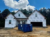New construction home with covered front porch and two-car garage on a sunny day at 146 Seahawk Way, Zebulon, NC 27597