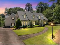 Charming two-story home boasts a lush lawn, beautiful landscaping, and inviting stone walkway at 1610 Ridge Rd, Raleigh, NC 27607