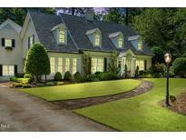 Charming two-story home with a well-manicured lawn, stone walkway, and inviting front porch at 1610 Ridge Rd, Raleigh, NC 27607