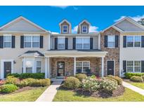Charming townhome exterior featuring a stone facade, dormer windows and manicured landscaping at 1725 T W Alexander Dr # 204, Durham, NC 27703