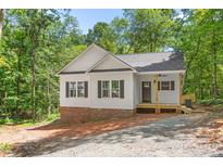 Charming exterior view of a home with white siding, brick foundation, and a covered front porch at 1952 Lewis Dr, Burlington, NC 27215