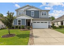 Charming two-story home with a two-car garage, well-manicured lawn, and beautiful landscaping at 209 S Harrison Place Ln, Fuquay Varina, NC 27526