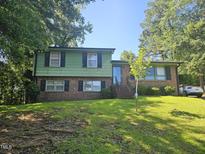 Charming two-story home with a brick facade and a well-manicured lawn in a shady neighborhood at 2308 Blacklan Cir, Raleigh, NC 27610